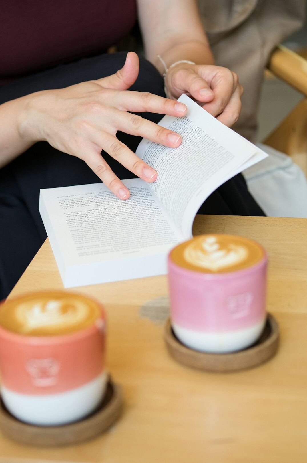 Woman journaling with a cup of coffee at a cafe table